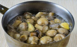 Положите очищенные грибы в кастрюлю с маринадом и варите все в течение 5-6 минут. Наконец, добавьте чеснок.