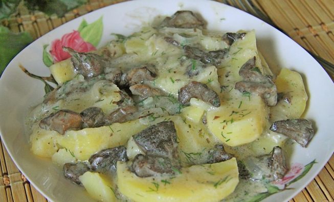 Картофель и грибы в сковороде со сметаной под крышкой