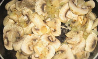 Разогрейте сковороду с растительным маслом. Здесь сначала обжаривают лук, а затем добавляют грибы. Посолите и приправьте содержимое. Готовьте примерно 15 минут.