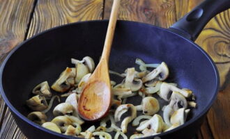 Нарежьте лук и грибы. Обжарьте их на растительном масле до мягкости.